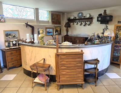 a kitchen with a counter, chairs, cabinets, and a mirror