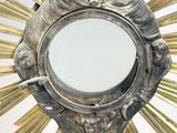 a silver and gold sunburst with a mirror in it