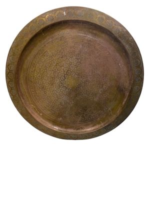an old brass plate with a decorative design on the rim