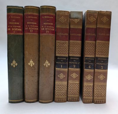 six vieux livres sont alignés sur une surface blanche