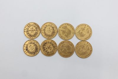 un groupe de cinq pièces d'or posées sur une surface blanche