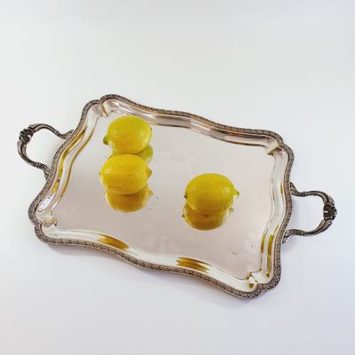 a tray with lemons on it on a white surface