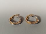 a pair of gold and silver hoop earrings