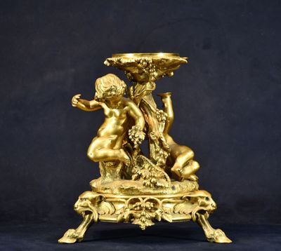 une statue en or représentant un garçon et une fille tenant un bol