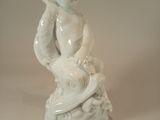 une figurine représentant un garçon tenant un couteau à la main