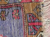 close up of a colorful rug with fringes on top of it