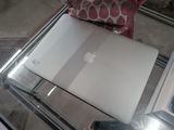 a white apple laptop sitting on a glass table