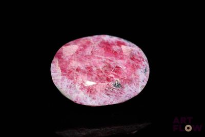 a picture of a pink and white stone on a black surface