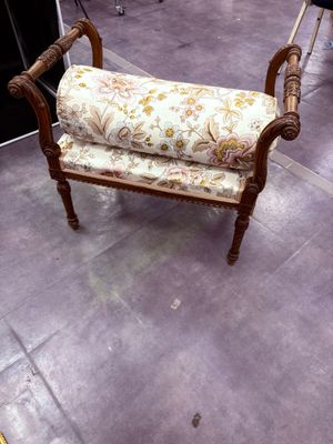 un banc sur lequel est posé un coussin recouvert d'un tissu à motifs floraux