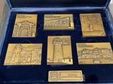 six gold medals in a case with a blue velvet lining
