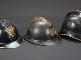 three helmets are sitting side by side on a gray surface