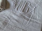 a white towel with a monogram on it next to a pair of scissors