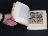 a person holding an open book on a table