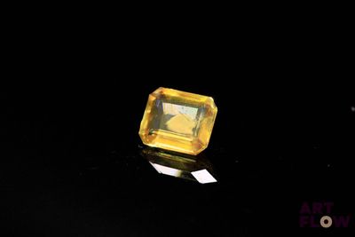 a close up of a yellow diamond on a black surface