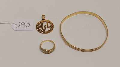 un gros plan sur une bague en or, une bague et une autre bague posées sur une surface blanche