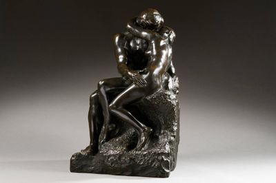 une statue représentant un homme et une femme assis sur un rocher