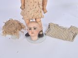 a doll and a doll head sitting on a table