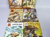 six bandes dessinées sont alignées sur une table