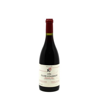 the bottle of red wine is sitting on a white surface