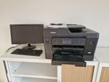 a printer sitting on a desk next to a computer monitor