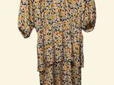 a yellow and black floral dress hanging on a white hanger
