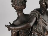 an antique bronze statue of two women holding hands
