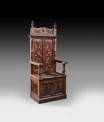 une vieille chaise en bois dont le dossier et l'assise sont sculptés