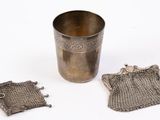 an old silver cup with a chain around it and a chain around the cup