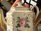 a person holding a tea pot in their hand