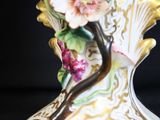 a white vase with flowers on it on a black background