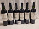 six bottles of wine are lined up on a table