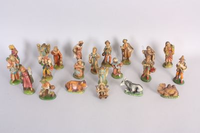 many figurines of people and animals on a white surface