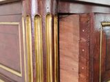 a close up of a wooden dresser with a marble top