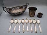 several silver spoons and a bowl are sitting next to each other