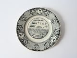 a black and white plate with a picture of a town on it