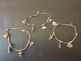 trois bracelets ornés de breloques, posés sur une table