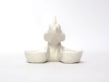 a white candle that is sitting on a white table