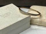an image of a gold bang with diamonds on it sitting on top of a box