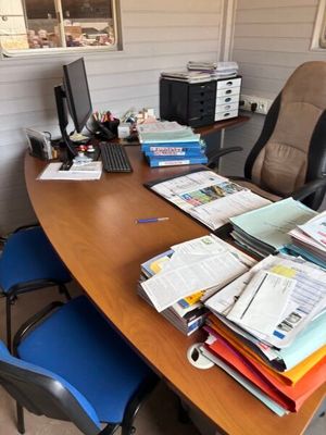 un bureau sur lequel se trouvent de nombreux papiers et un ordinateur