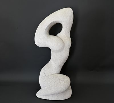 une sculpture blanche posée sur une table près d'un mur noir