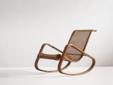 un fauteuil à bascule en bois avec une assise en osier, posé sur une surface blanche