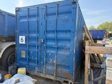 a large blue container sitting on the ground next to a truck