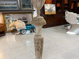 une statue au milieu d'une pièce, avec une télévision en arrière-plan