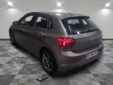 the back end of a silver car in a room with a checkered floor