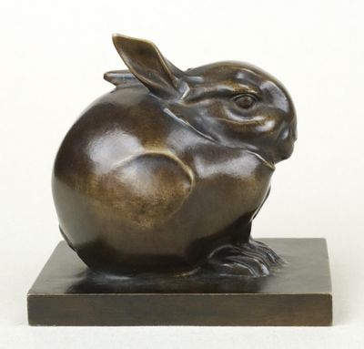 sculpture en bronze représentant un lapin, posée sur un socle en marbre, sur fond blanc