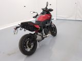 a red and black motorcycle parked in a white room