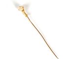 a gold stick with a flower on it on a white surface