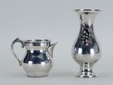 deux vases en argent posés l'un à côté de l'autre sur une table