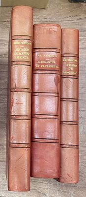 quatre livres sur une étagère, avec une horloge en arrière-plan