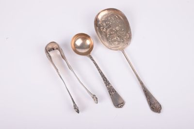 trois cuillères et deux cuillères en argent sur une surface blanche